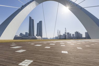 Panoramik siluet ve boş yolu, boş beton zemini olan modern iş binaları.