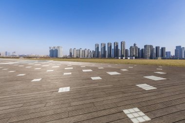 Panoramik siluet ve boş yolu, boş beton zemini olan modern iş binaları.