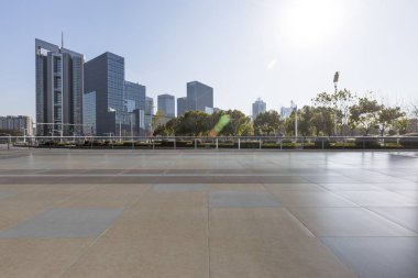 Panoramik siluet ve boş yolu, boş beton zemini olan modern iş binaları.