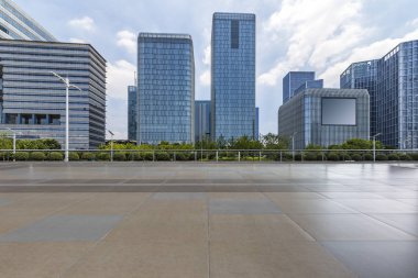 Panoramik siluet ve boş yolu, boş beton zemini olan modern iş binaları.