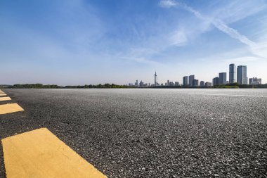 Panoramik siluet ve boş yolu, boş beton zemini olan modern iş binaları.