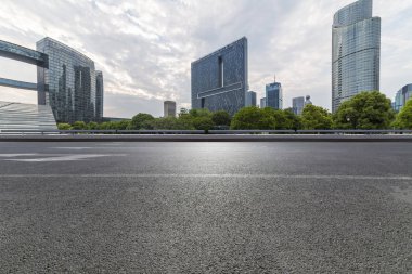 Panoramik siluet ve boş yolu, boş beton zemini olan modern iş binaları.