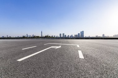 Panoramik siluet ve boş yolu, boş beton zemini olan modern iş binaları.