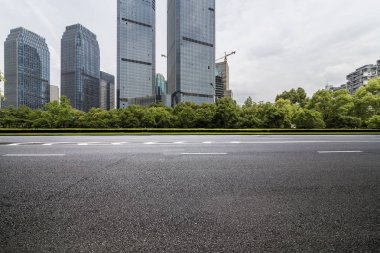 Panoramik siluet ve boş yolu, boş beton zemini olan modern iş binaları.