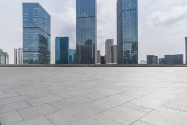 Panoramik siluet ve boş yolu, boş beton zemini olan modern iş binaları.