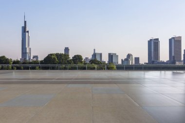 Panoramik siluet ve boş yolu, boş beton zemini olan modern iş binaları.