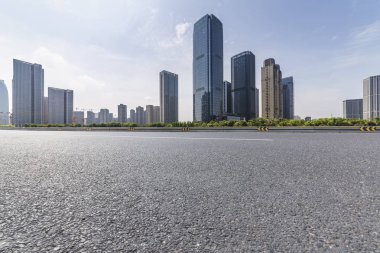 Panoramik siluet ve boş yolu, boş beton zemini olan modern iş binaları.