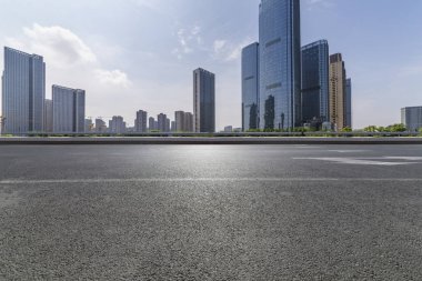 Panoramik siluet ve boş yolu, boş beton zemini olan modern iş binaları.