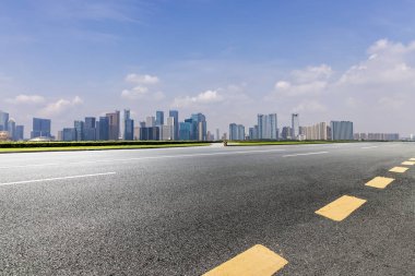 Panoramik siluet ve boş yolu, boş beton zemini olan modern iş binaları.