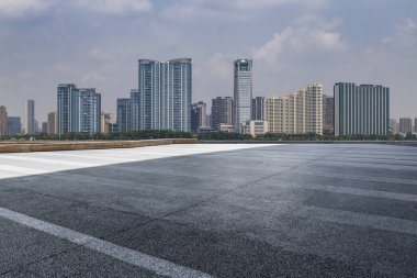 Panoramik siluet ve boş yolu, boş beton zemini olan modern iş binaları.