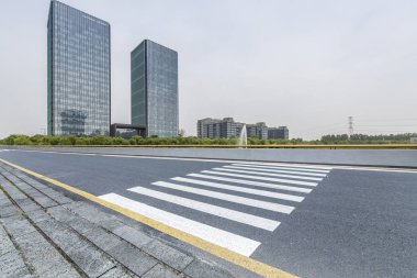 Panoramik siluet ve boş yolu, boş beton zemini olan modern iş binaları.