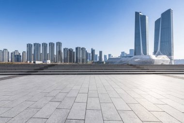 Panoramik siluet ve boş yolu, boş beton zemini olan modern iş binaları.
