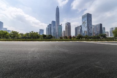 Panoramik siluet ve boş yolu, boş beton zemini olan modern iş binaları.