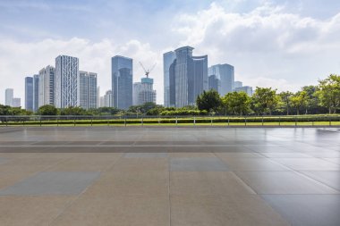 Panoramik siluet ve boş yolu, boş beton zemini olan modern iş binaları.