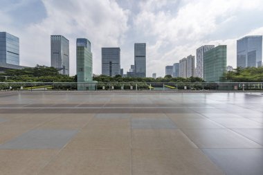 Panoramik siluet ve boş yolu, boş beton zemini olan modern iş binaları.