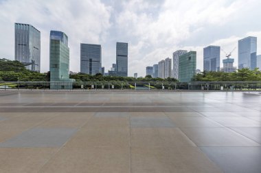Panoramik siluet ve boş yolu, boş beton zemini olan modern iş binaları.