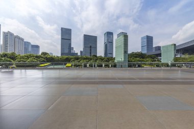 Panoramik siluet ve boş yolu, boş beton zemini olan modern iş binaları.