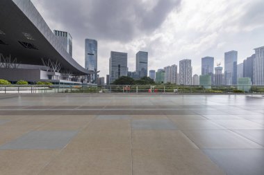 Panoramik siluet ve boş yolu, boş beton zemini olan modern iş binaları.