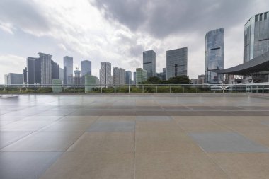 Panoramik siluet ve boş yolu, boş beton zemini olan modern iş binaları.