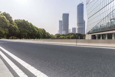 Panoramik siluet ve boş yolu, boş beton zemini olan modern iş binaları.