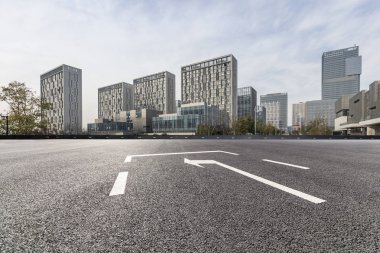 Panoramik siluet ve boş yolu, boş beton zemini olan modern iş binaları.