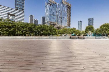 Panoramik siluet ve boş yolu, boş beton zemini olan modern iş binaları.