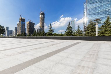 Panoramik siluet ve boş yolu, boş beton zemini olan modern iş binaları.