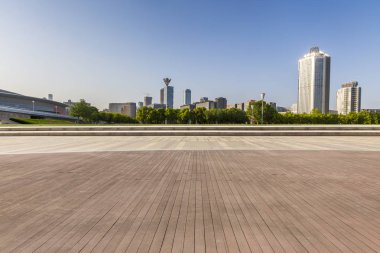 Panoramik siluet ve boş yolu, boş beton zemini olan modern iş binaları.