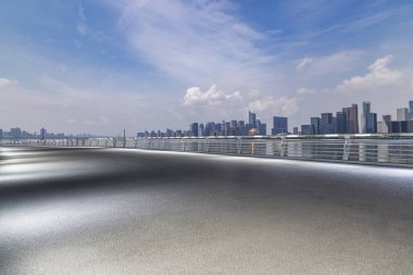 Panoramik siluet ve boş yolu, boş beton zemini olan modern iş binaları.