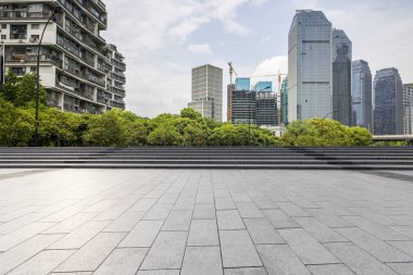 Panoramik siluet ve boş yolu, boş beton zemini olan modern iş binaları.