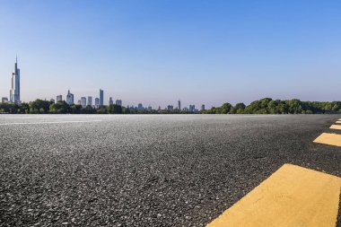 Panoramik siluet ve boş yolu, boş beton zemini olan modern iş binaları.