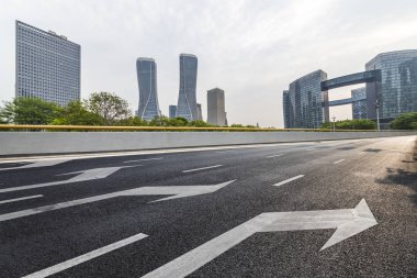 Panoramik siluet ve boş yolu, boş beton zemini olan modern iş binaları.