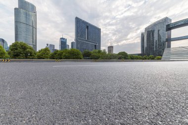 Panoramik siluet ve boş yolu, boş beton zemini olan modern iş binaları.