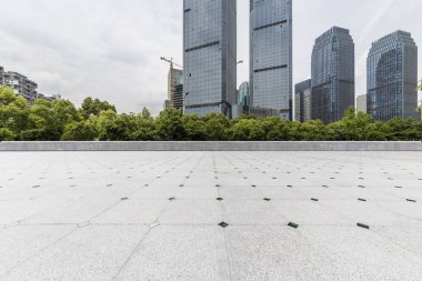 Panoramik siluet ve boş yolu, boş beton zemini olan modern iş binaları.