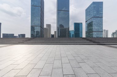 Panoramik siluet ve boş yolu, boş beton zemini olan modern iş binaları.
