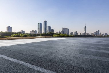 Panoramik siluet ve boş yolu, boş beton zemini olan modern iş binaları.