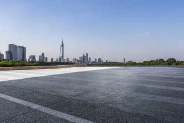 Panoramik siluet ve boş yolu, boş beton zemini olan modern iş binaları.