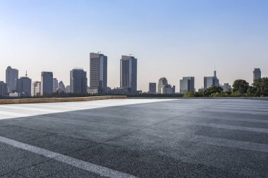 Panoramik siluet ve boş yolu, boş beton zemini olan modern iş binaları.