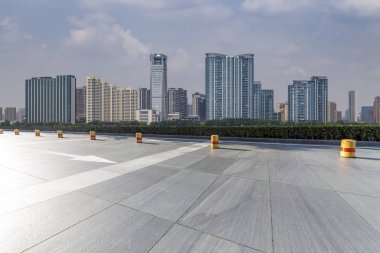 Panoramik siluet ve boş yolu, boş beton zemini olan modern iş binaları.