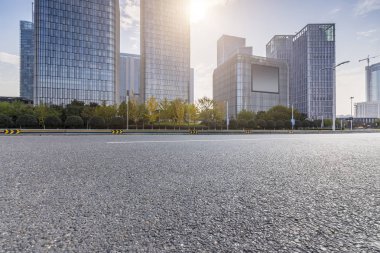 Panoramik siluet ve boş yolu, boş beton zemini olan modern iş binaları.