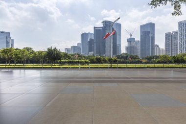 Panoramik siluet ve boş yolu, boş beton zemini olan modern iş binaları.