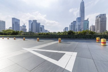 Panoramik siluet ve boş yolu, boş beton zemini olan modern iş binaları.