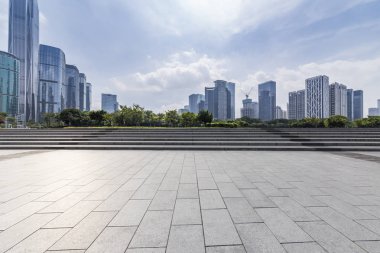 Panoramik siluet ve boş yolu, boş beton zemini olan modern iş binaları.