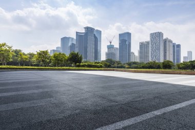 Panoramik siluet ve boş yolu, boş beton zemini olan modern iş binaları.