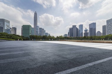 Panoramik siluet ve boş yolu, boş beton zemini olan modern iş binaları.