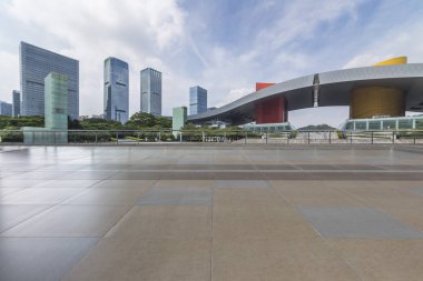 Panoramik siluet ve boş yolu, boş beton zemini olan modern iş binaları.