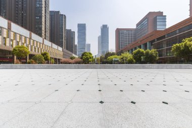 Panoramik siluet ve boş yolu, boş beton zemini olan modern iş binaları.