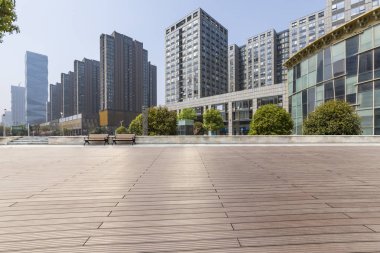 Panoramik siluet ve boş yolu, boş beton zemini olan modern iş binaları.