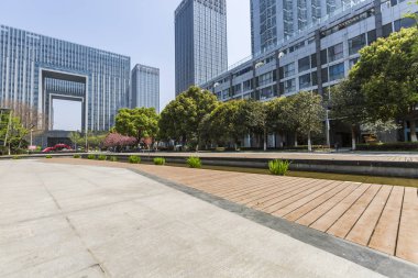 Panoramik siluet ve boş yolu, boş beton zemini olan modern iş binaları.