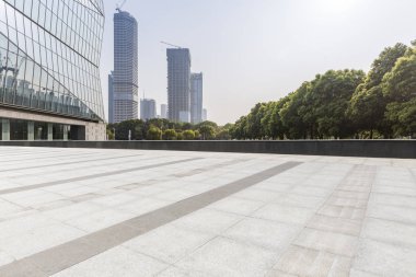 Panoramik siluet ve boş yolu, boş beton zemini olan modern iş binaları.